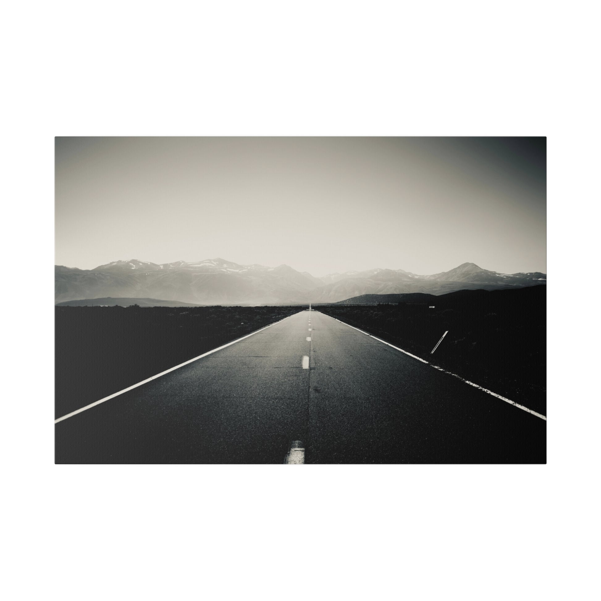 Black and white lonely highway canvas print with distant mountains, original photography by Keith Cutrone
